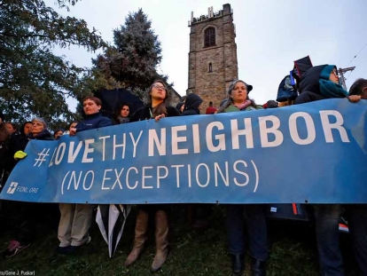 Mourners hold up a sign near the Tree of Life Synagogue in Pittsburgh where a gunman opened fire Saturday, killing 11 people and injuring six others
