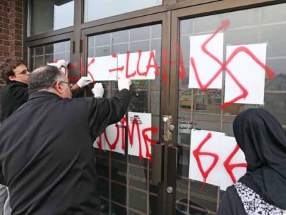 Hate graffiti on the Ottawa Mosque on Northwestern Ave being removed, November 18, 2016