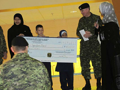 Students from the Edmonton Islamic Academy present a cheque to representatives from the Canadian Armed Forces.